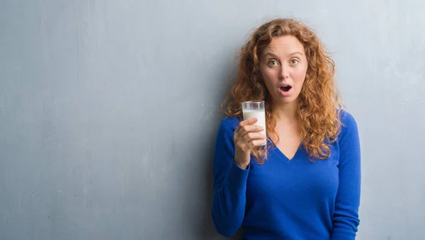 Νέοι Κοκκινομάλλα Γυναίκα Πίνοντας Ποτήρι Γάλα Που Φοβάται Σοκ Πρόσωπο — Φωτογραφία Αρχείου