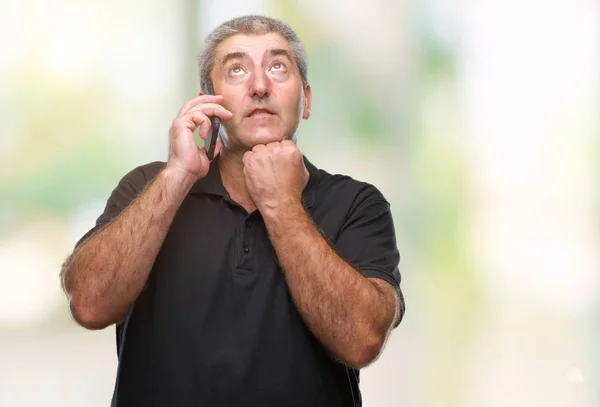 Красивый Пожилой Человек Говорит Смартфону Изолированном Фоне Серьезное Лицо Думая — стоковое фото