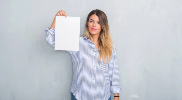 Jovem Mulher Adulta Sobre Parede Grunge Cinza Segurando Folha Papel — Fotografia de Stock