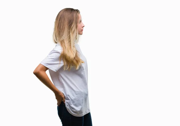 年轻美丽的金发女子穿着休闲白色 T恤在孤立的背景寻找侧 放松的轮廓姿势与自然脸与自信的微笑 — 图库照片