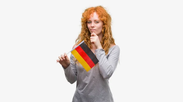 Joven Pelirroja Sosteniendo Bandera Alemania Cara Seria Pensando Pregunta Idea — Foto de Stock