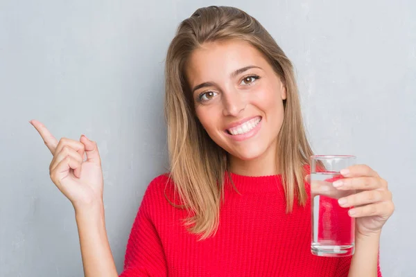 Vacker Ung Kvinna Över Grunge Grå Vägg Dricka Ett Glas — Stockfoto