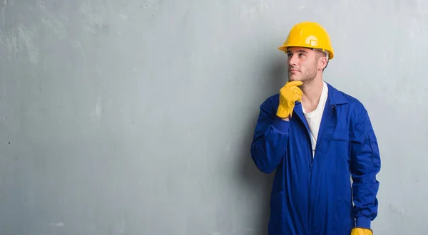 Joven Caucásico Hombre Sobre Gris Grunge Pared Usando Contratista Uniforme — Foto de Stock