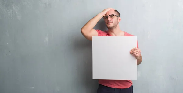 Young Caucasian Man Grey Grunge Wall Holding Blank Banner Stressed — Stock Photo, Image