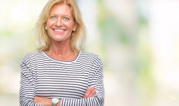 Middle age blonde woman over isolated background happy face smiling with crossed arms looking at the camera. Positive person.