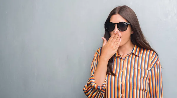 Junge Brünette Frau Über Grunge Grauer Wand Mit Großer Sonnenbrille — Stockfoto