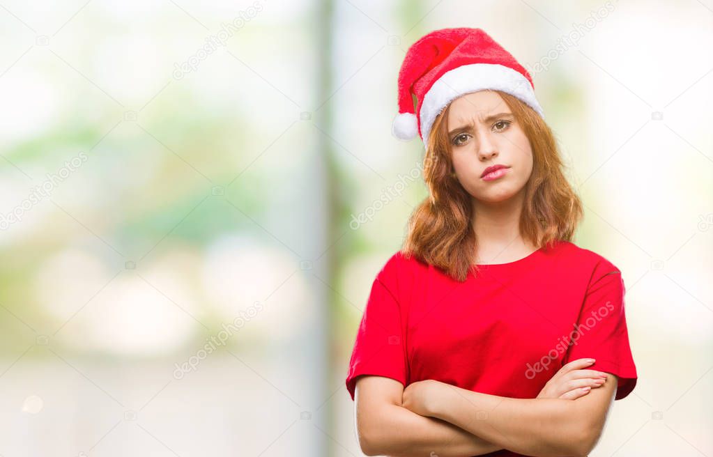 Young beautiful woman over isolated background wearing christmas hat skeptic and nervous, disapproving expression on face with crossed arms. Negative person.