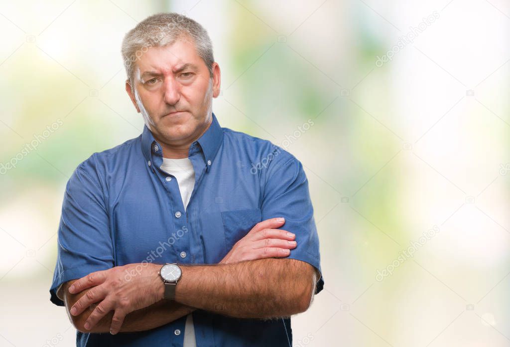 Handsome senior man over isolated background skeptic and nervous, disapproving expression on face with crossed arms. Negative person.