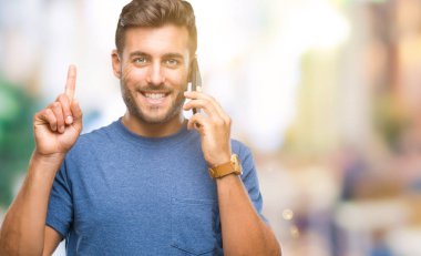 Yakışıklı delikanlı Smartphone'da izole arka plan üzerinde bir fikir veya parmakla gülen yüz, bir numara ile soru ile sürpriz konuşuyor