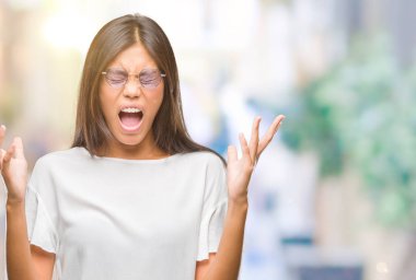 Kızgın ve çığlık kaldırdı ve kapalı gözleri heyecanlı silah ile başarı için deli kutluyor izole arka plan üzerinde gözlük takan Genç Asyalı kadın. Kazanan kavramı