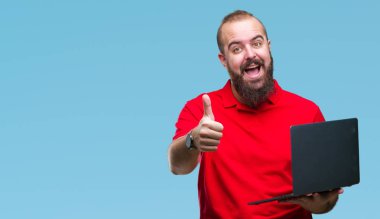 Ok işareti, başparmak ile parmak, mükemmel işareti yapıyor kocaman bir gülümseme ile izole arka plan üzerinde mutlu bilgisayar dizüstü kullanan genç beyaz adam