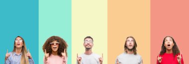 Kolaj grup renkli vintage izole arka plan üzerinde genç insan hayret ve yukarıya bakıyor ve parmakları ile işaret ve silah kaldırdı şaşırttı.