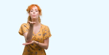 Bir öpücük el ile güzel ve seksi olmak hava üfleme kamera arayan genç Kızıl saçlı kadın. Aşk ifade.