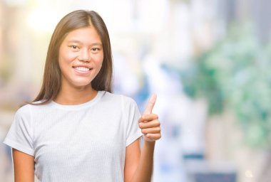 Genç Asyalı kadın hareketi el ile mutlu yaşasın yapıyor izole arka plan üzerinde. Kameraya bakarak başarı gösteren ile ifade onaylama.