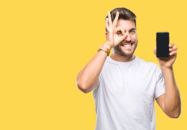 Yakışıklı delikanlı Smartphone ekran ile mutlu yüz el parmaklarının arasından seyir göz üzerinde ok işaretiyle yapıyor gülümseyen izole arka plan üzerinde gösterilen