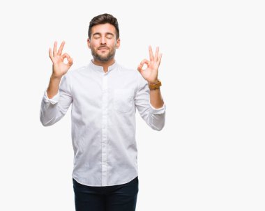 Yakışıklı delikanlı izole arka plan üzerinde dinlenmek ve gülümseyen gözlerle parmak ile meditasyon jest yapıyor kapalı. Yoga kavramı.