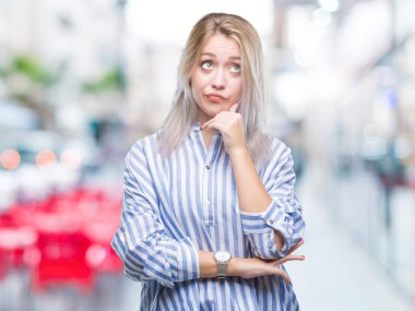 Genç Sarışın kadın elle çene düşünme hakkında soru, dalgın ifade izole arka plan yüzünden. Düşünceli yüzüyle gülümsüyor. Şüphe kavramı.