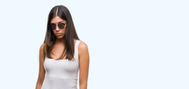 Genç güzel İspanyol güneş gözlüğü şüpheci ve sinir, papatyanın üzgün sorunu nedeniyle giyiyor. Negatif kişi.