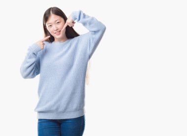 Genç Çinli kadın yüzünden arka plan emin gösterilen ve işaret parmakları diş ve ağız ile gülümseyen izole. Sağlık kavramı.