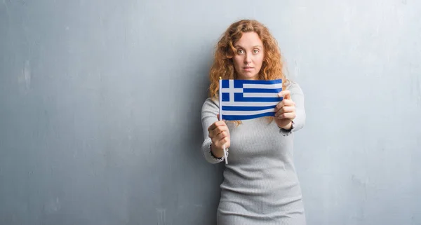 Jovem Ruiva Sobre Parede Grunge Cinza Segurando Bandeira Grécia Com — Fotografia de Stock