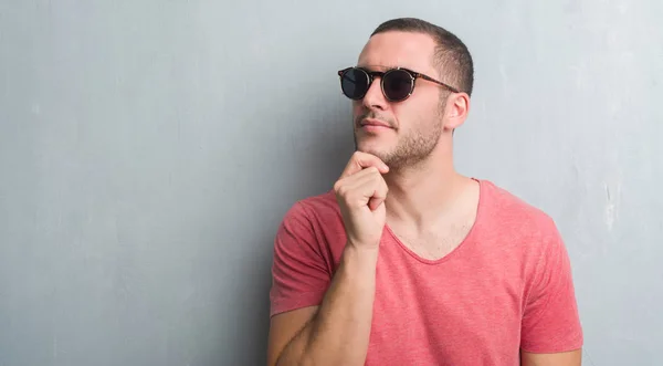 Young Caucasian Man Grey Grunge Wall Wearing Sunglasses Serious Face — Stock Photo, Image