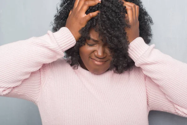 年轻的非洲裔美国人加上大小的女人在灰色的垃圾墙穿着冬季毛衣头痛绝望和压力 因为疼痛和偏头痛 手在头上 — 图库照片
