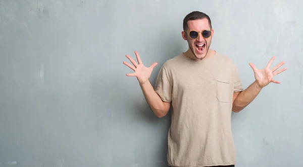 Joven Hombre Caucásico Sobre Pared Gris Grunge Con Gafas Sol —  Fotos de Stock