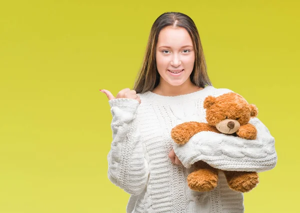 Joven Mujer Caucásica Sosteniendo Osito Peluche Sobre Fondo Aislado Apuntando —  Fotos de Stock