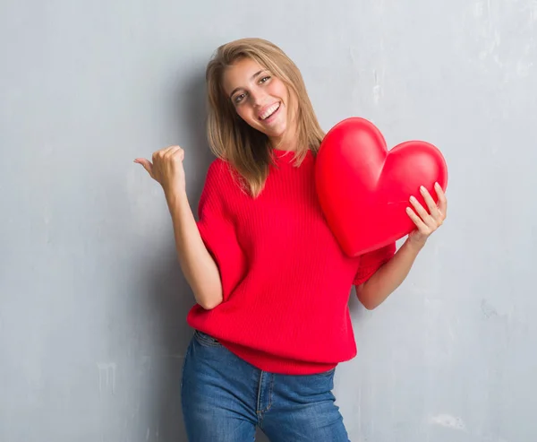 Schöne Junge Frau Über Grunge Grauer Wand Rotes Herz Zeigend — Stockfoto