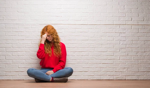 レンガの壁に座っている赤毛の若い女性は ラビング鼻と目の疲労や頭痛を感じに疲れています ストレスと欲求不満のコンセプト — ストック写真