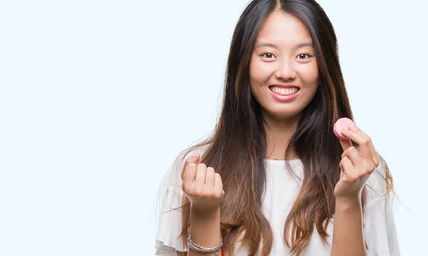 年轻的亚洲妇女吃粉红色的 Macaron 甜在孤立的背景尖叫自豪和庆祝胜利和成功非常兴奋 欢呼的情绪 — 图库照片