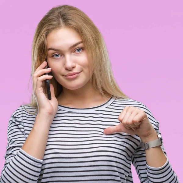 年轻的白种人妇女显示智能手机屏幕在孤立的背景与惊讶的脸指向自己的手指 — 图库照片