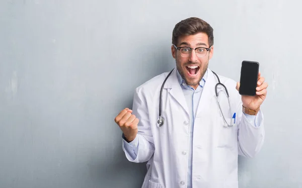 Bonito Jovem Médico Homem Sobre Parede Grunge Cinza Segurando Smartphone — Fotografia de Stock