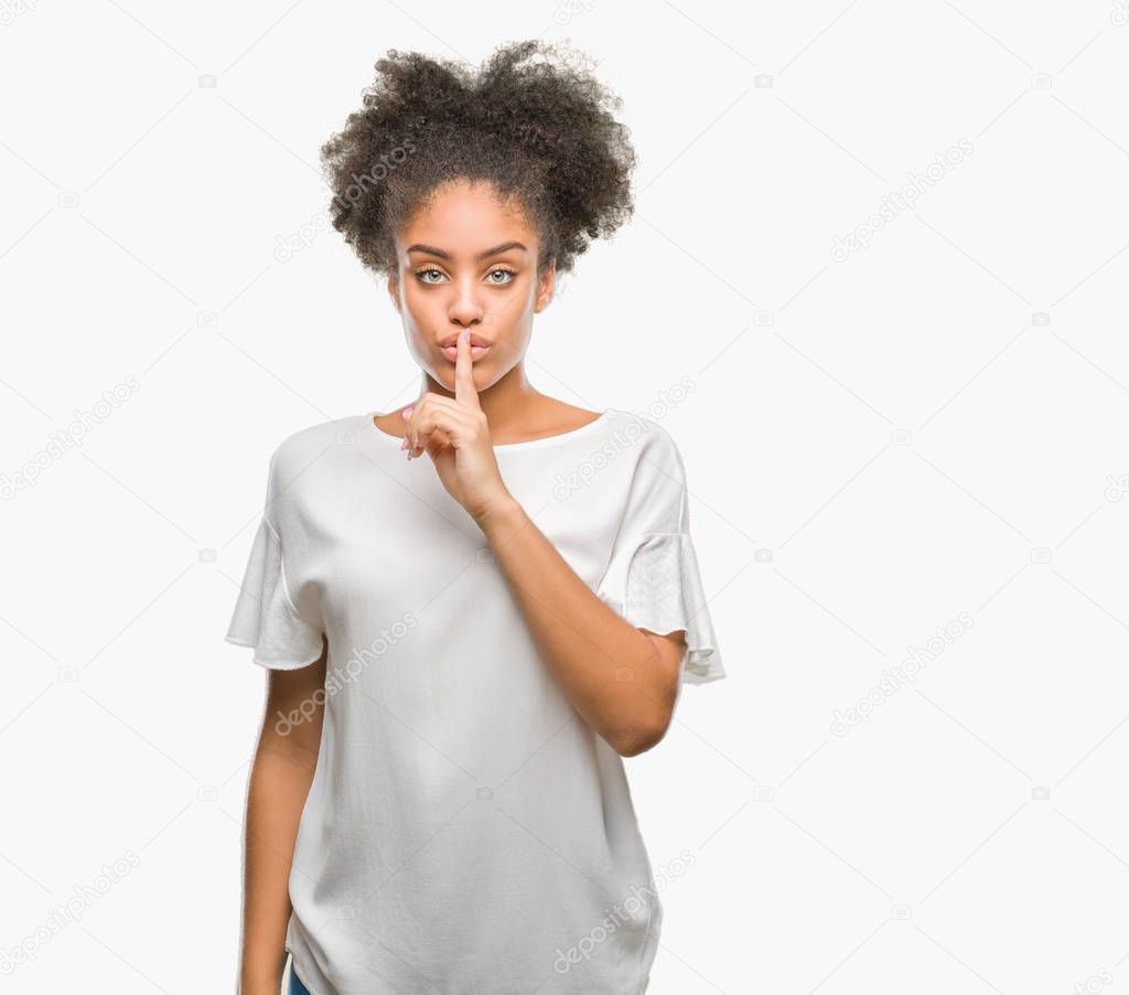 Young afro american woman over isolated background asking to be quiet with finger on lips. Silence and secret concept.