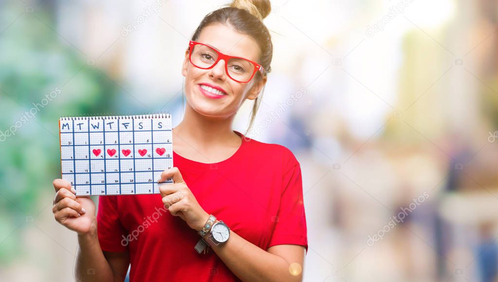 Young beautiful woman holding menstruation calendar over isolated background with a happy face standing and smiling with a confident smile showing teeth
