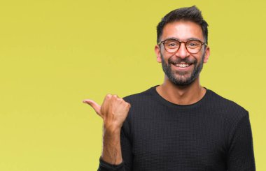 Yetişkin İspanyol adam arıyor ve başparmak yanında yukarıyı mutlu yüz ile gülümseyen izole arka plan üzerinde gözlük.