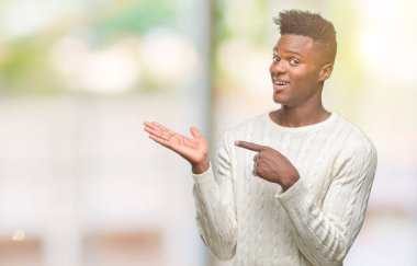 Genç Afro-Amerikan adam üzerinden hayran ve el ile sunulması ve parmak ile işaret ederken kameraya gülümseyen izole arka plan.