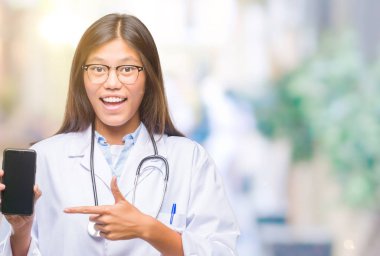 Smartphone izole arka plan üzerinde çok mutlu el ve parmak ile işaret tutan Genç Asyalı doktor kadın