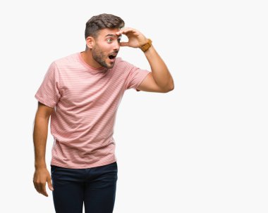 Yakışıklı delikanlı izole arka plan çok mutlu ve gülümseyen uzakta el ile üzerine kafa seyir üzerinde. Arama kavramı.