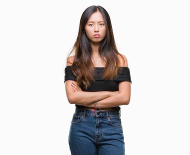 Genç Asyalı kadın izole arka plan şüpheci ve çapraz kolları olan yüzündeki gergin, onaylamayan ifade yüzünden. Negatif kişi.