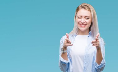 Sarışın genç kadın için fotoğraf makinesi ile mutlu ve komik yüz parmakları işaret izole arka plan üzerinde. İyi enerji ve vibes.