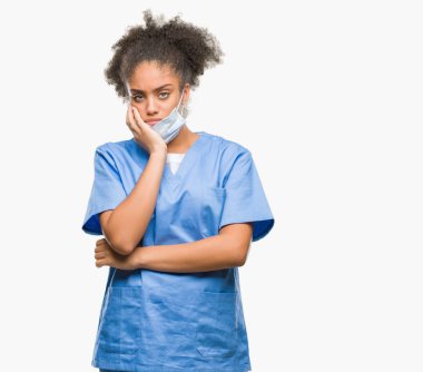 Genç afro Amerikalı doktor kadın yorgun ve bıkkın ile depresyon sorun Çapraz kollar ile seyir düşünüyorum izole arka plan.