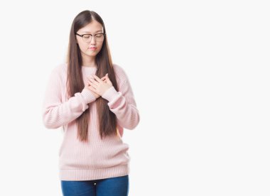 Gözlüklü kapalı gözler ile göğüs ellerinde ve yüzünde minnettar jest ile gülümseyen izole arka plan üzerinde Genç Çinli kadın. Sağlık kavramı.