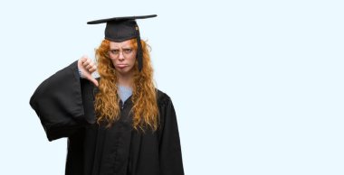 Kızgın yüz, eksi işareti aşağı antipati başparmak ile gösterilen, ret kavramı ile üniforma giyen genç redhead öğrenci kadın mezun