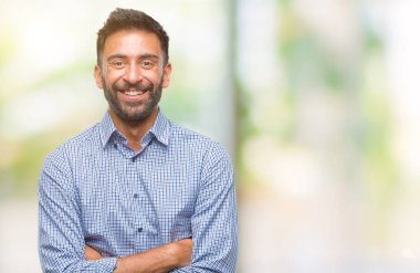 Kameraya bakarak çapraz silah ile gülümseyen izole arka plan mutlu yüz yetişkin İspanyol adam. Olumlu bir kişi.