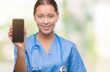 Smarpthone duran ve diş gösterilen kendine güvenen bir gülümsemeyle gülümseyerek mutlu bir yüz ile izole arka plan üzerinde gösterilen Genç beyaz doktor kadın