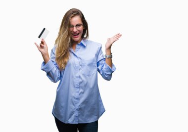 Kredi kartı ile büyük gülümseme çığlık ve ellerini kaldırdı izole arka plan çok mutlu ve heyecanlı, kazanan ifade kutluyor üzerinde zafer tutan genç güzel sarışın kadın