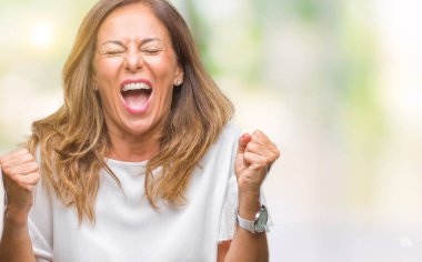 İzole arka plan kutlama üzerinde orta yaş İspanyol kadın kıdemli şaşırttı ve başarı için kaldırdı kollarını açarak hayret ve gözleri açık. Kazanan kavramı.