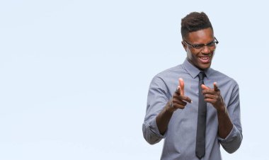 Fotoğraf makinesi ile mutlu ve komik yüz için parmakları işaret izole arka plan üzerinde genç Afro-Amerikalı iş adamı. İyi enerji ve vibes.