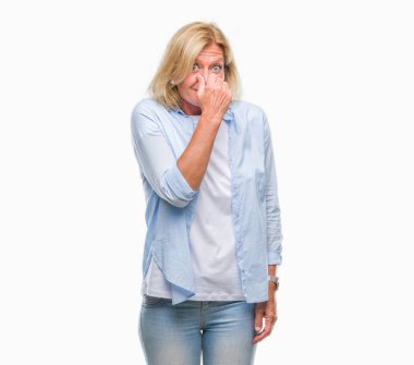 Bir şey pis ve iğrenç kokulu izole arka plan, dayanılmaz koku, holding nefes burun parmak ile orta yaş sarışın kadın. Kötü kokuyor kavramı.